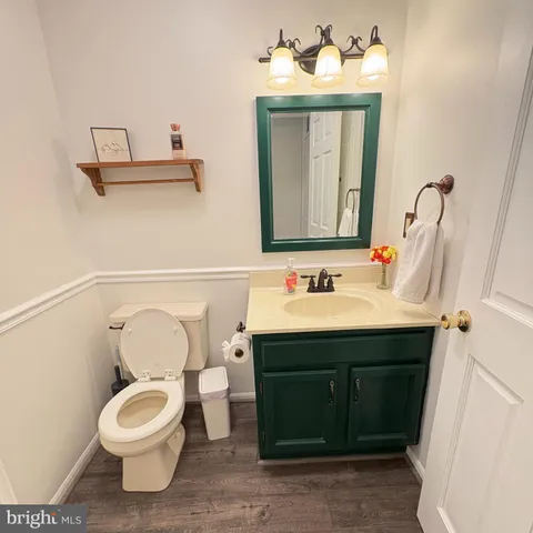 a bathroom with a toilet sink vanity tub and mirror