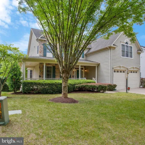 a view of a house with a yard and large tree