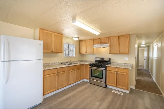 a kitchen with stainless steel appliances granite countertop a stove a refrigerator and a sink