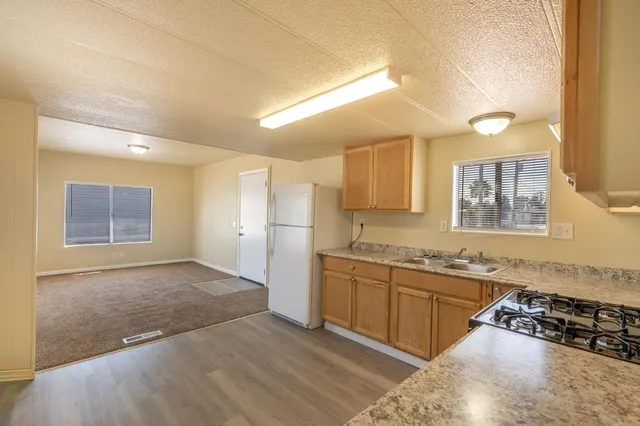 a large kitchen with stainless steel appliances granite countertop a sink and cabinets with wooden floor