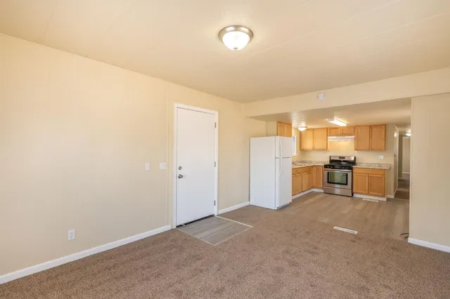 a view of a kitchen with refrigerator and chairs