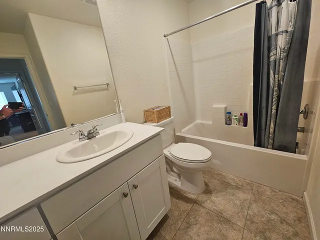 a bathroom with a granite countertop sink toilet a mirror and shower