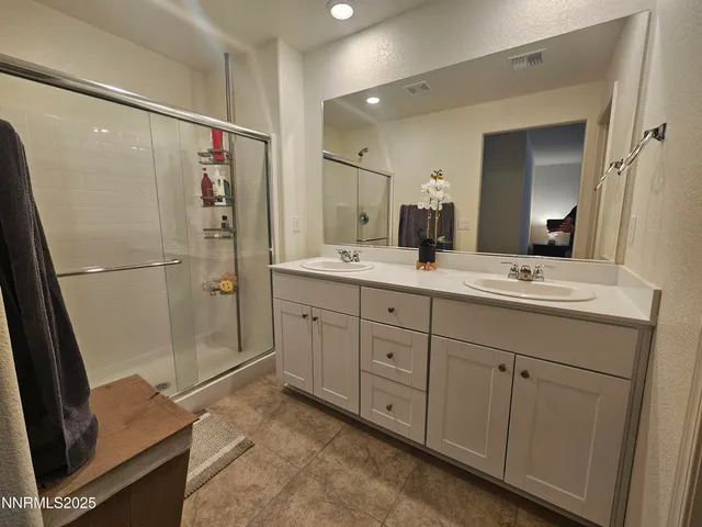a spacious bathroom with a shower sink and mirror
