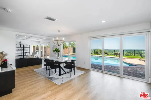 a living room with furniture a dining table and a large window