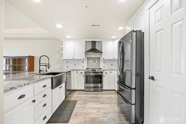 a kitchen with granite countertop a sink and a wooden floor