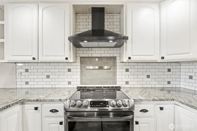 a kitchen with stainless steel appliances white cabinets and a refrigerator