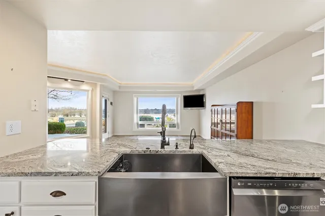 a kitchen with stainless steel appliances white cabinets and wooden floor