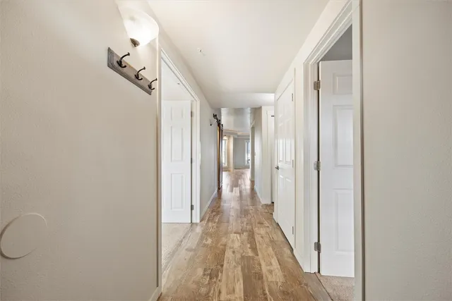 a view of a hallway with wooden floor and staircase
