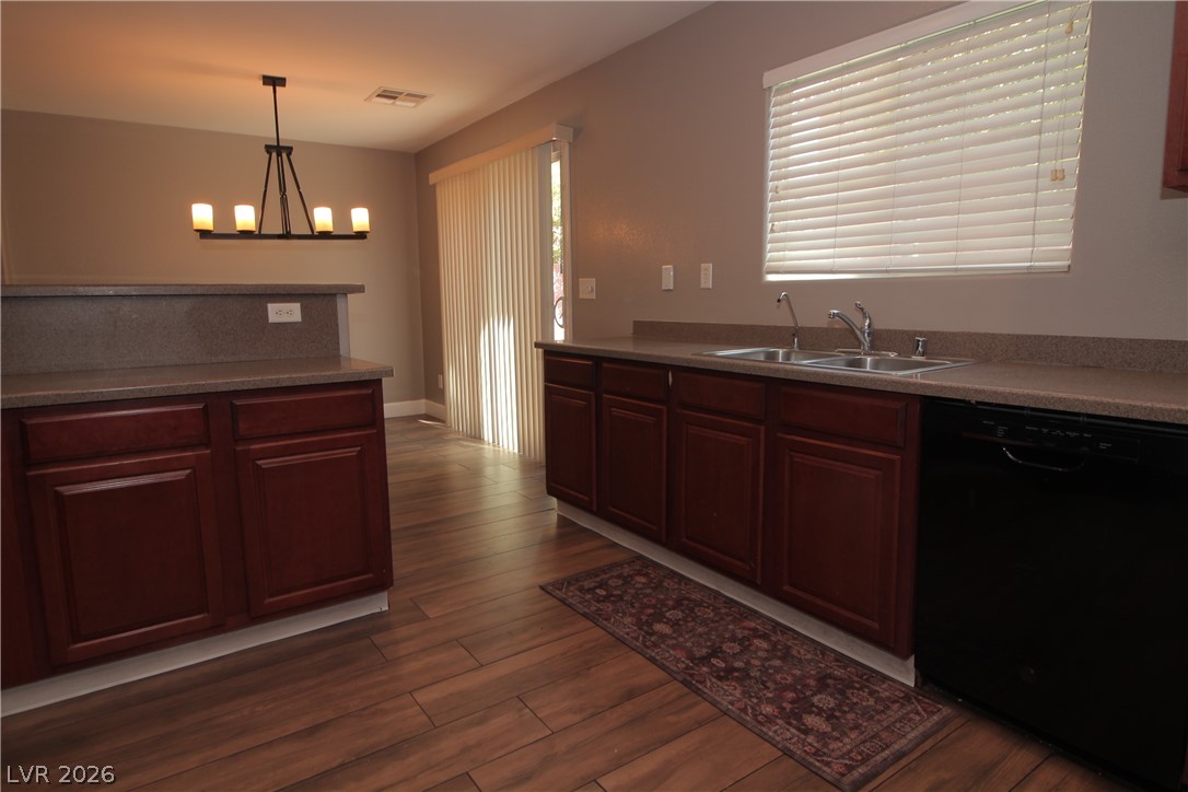 9289 Valley Ranch Avenue Las Vegas, NV 89178 - Photo 11 of 29 A functional kitchen boasts rich cabinetry, a convenient breakfast bar, and wood-look flooring.
