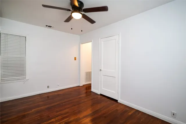 an empty room with wooden floor a ceiling fan and closet