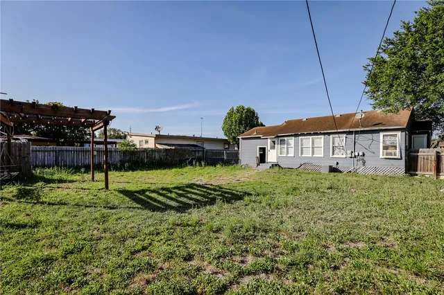 a view of a house with a yard and potted plants