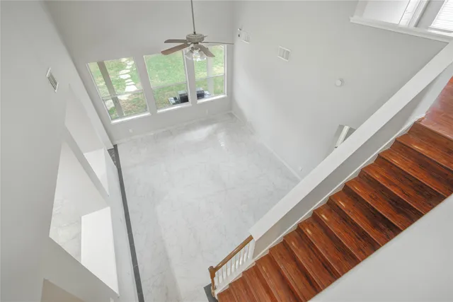 a view of a hallway with wooden floor and staircase