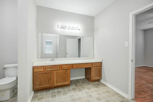 a bathroom with a sink toilet vanity and shower