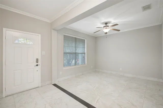 an empty room with windows and fan