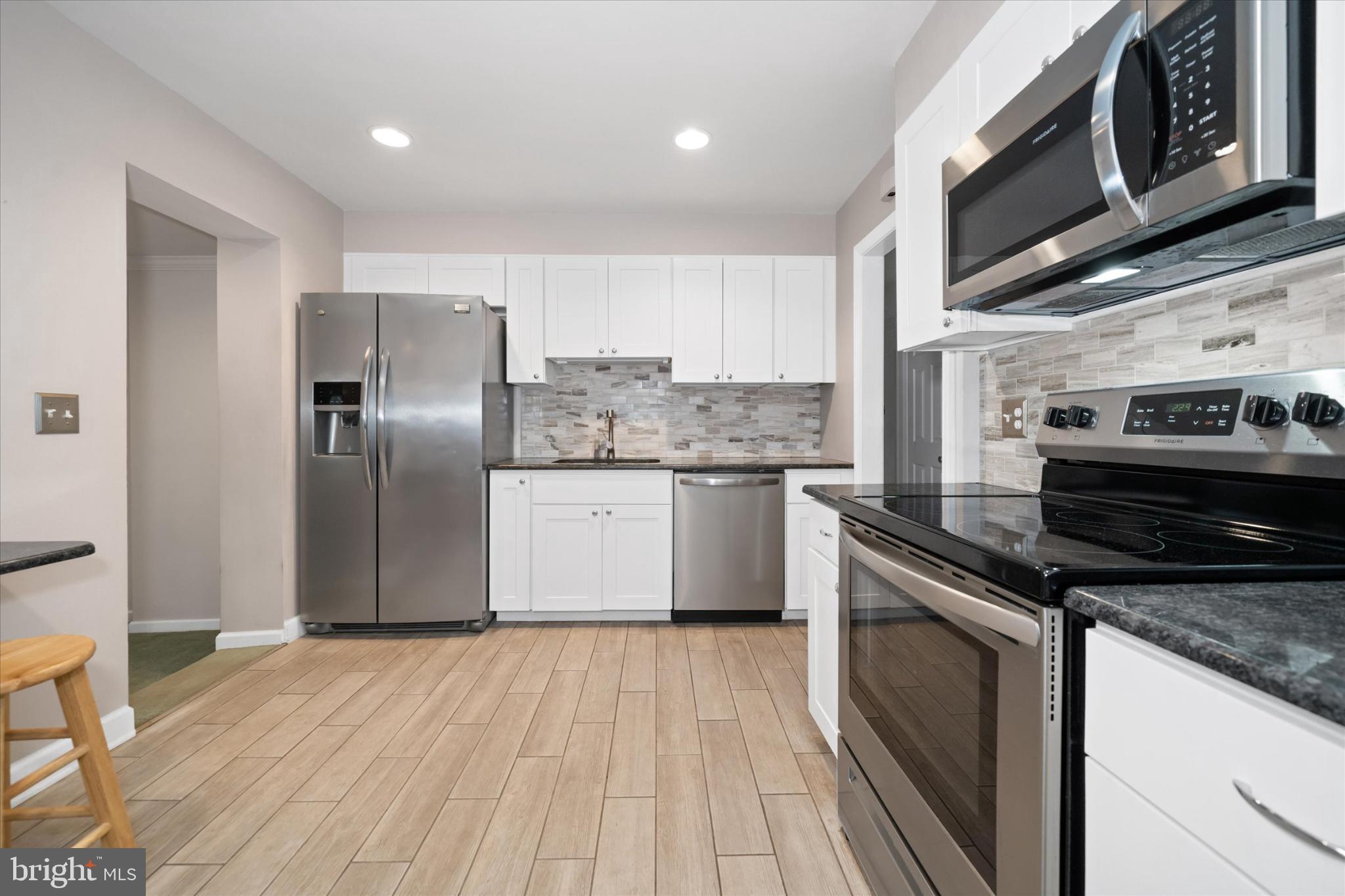 42 Paschall Road Wilmington, DE 19803 - Photo 11 of 41 a kitchen with stainless steel appliances granite countertop a stove a sink and a refrigerator
