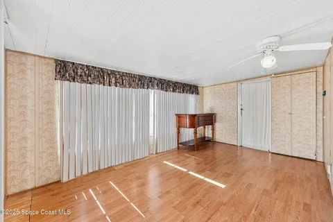 a view of an empty room with wooden floor