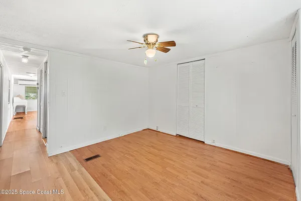 a view of empty room with wooden floor