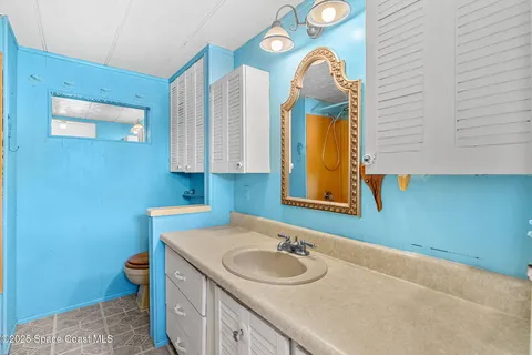 a bathroom with a sink and mirror with toilet