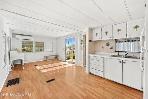 a room with a bed and a view of kitchen