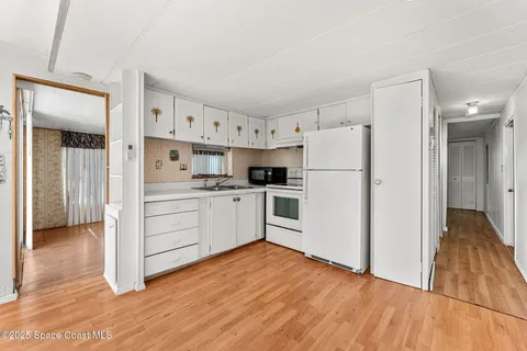 a kitchen with white cabinets and white appliances