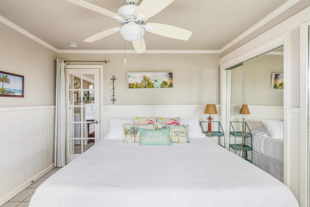 5061 Lawai Road, Unit 402 Koloa, HI 96756 - Photo 16 of 30 a bedroom with a bed and a chandelier