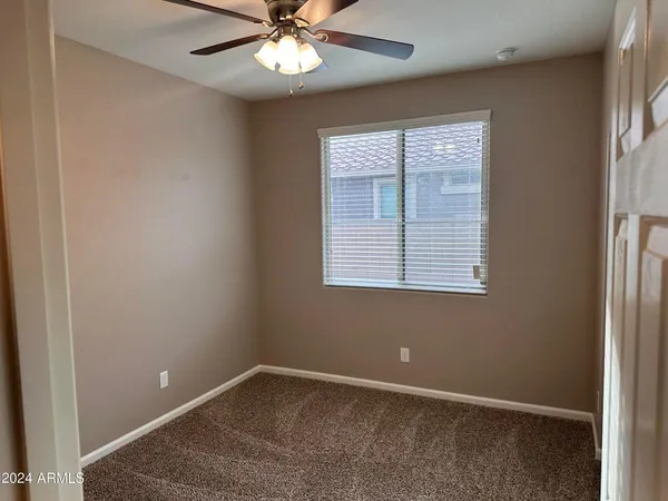 an empty room with windows and fan
