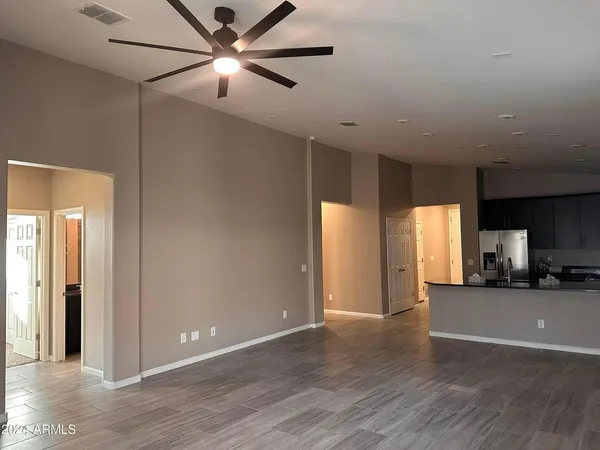 a view of a big room with wooden floor and a ceiling fan