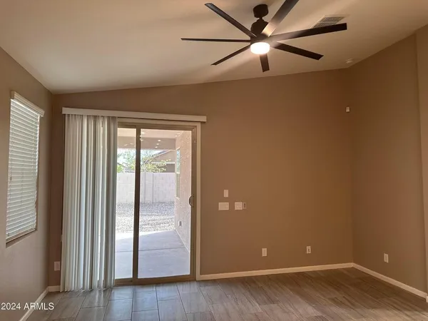 a view of a room with wooden floor and a ceiling fan