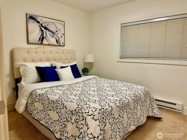 a bedroom with a bed and painting on the wall