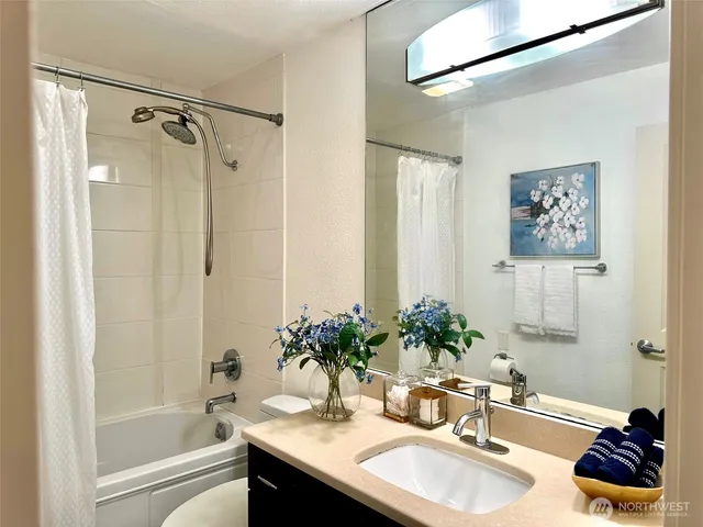 a bathroom with a granite countertop sink a large mirror and a shower