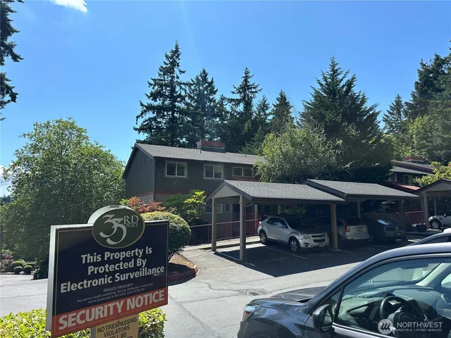 a front view of small house with garden space and car parked