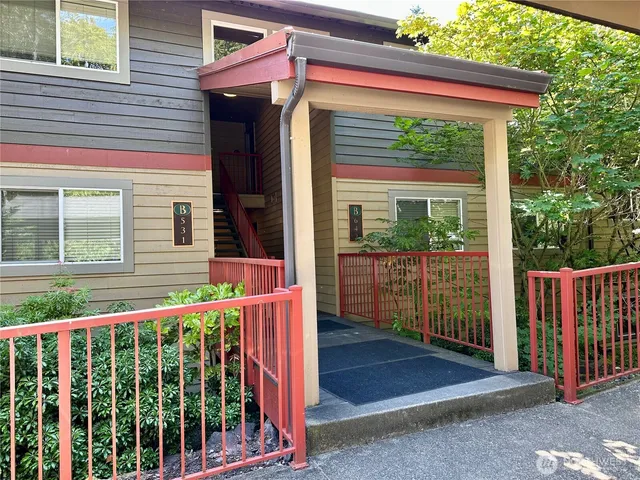 a view of a house with large windows and a small yard