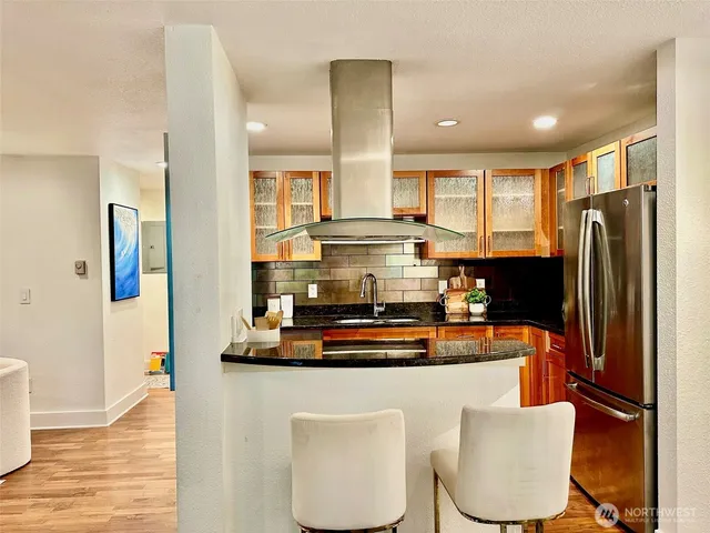 a dining table with chairs and kitchen view