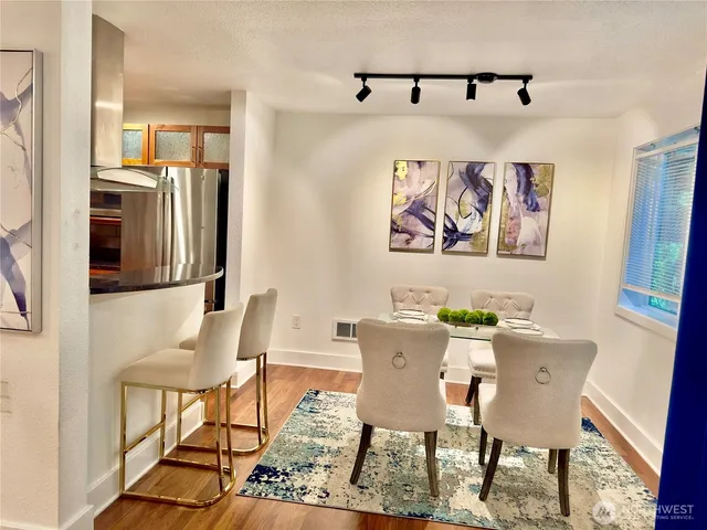 a view of a dining room with furniture a rug and wooden floor