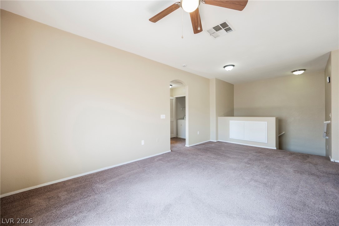 6320 Snap Ridge Street, Unit 201 North Las Vegas, NV 89081 - Photo 20 of 56 A versatile open space features soft carpeting and an archway leading to additional areas.