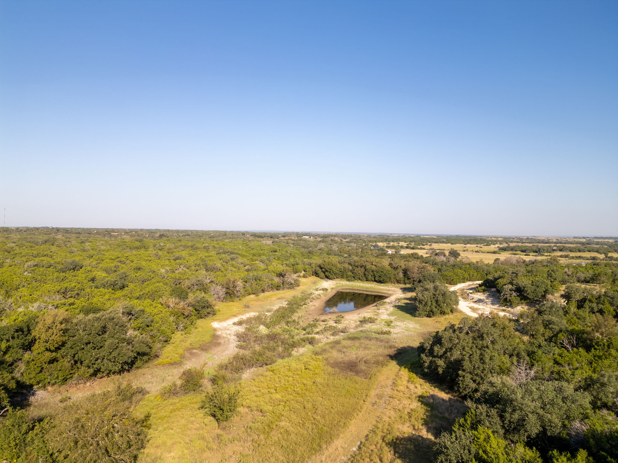 112 Loop 308 Briggs, TX 78608 - Photo 20 of 37 Bird's eye view of a nearby body of water and a forest