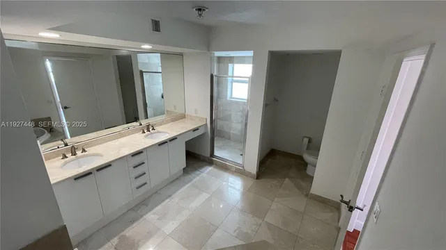a bathroom with a double vanity sink a mirror and a bathtub