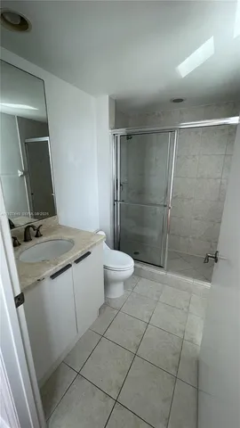 a bathroom with a granite countertop sink a toilet and shower