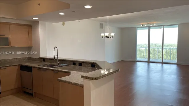 a kitchen that has a sink a microwave oven a stove and white cabinets with wooden floor