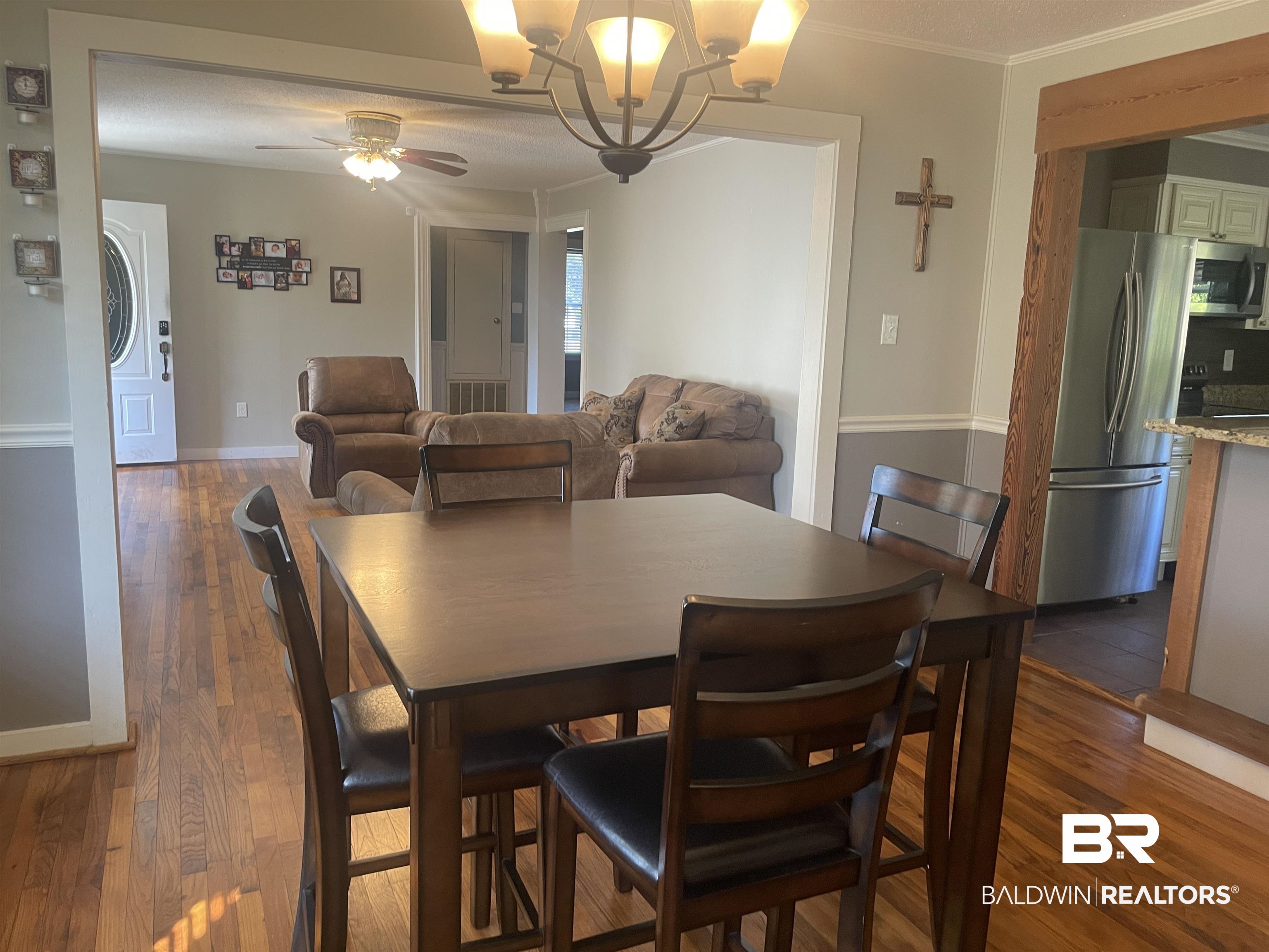 13850 Celeste Road Chunchula, AL 36521 - Photo 7 of 29 Dining area featuring dark wood-type flooring, a chandelier, ceiling fan, and ornamental molding