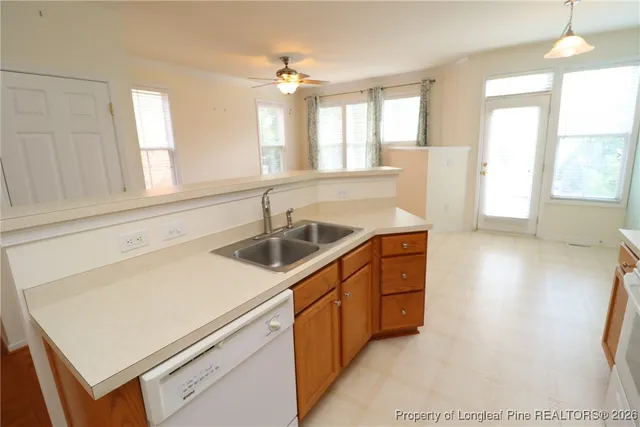 a kitchen with granite countertop a stove a sink and a microwave