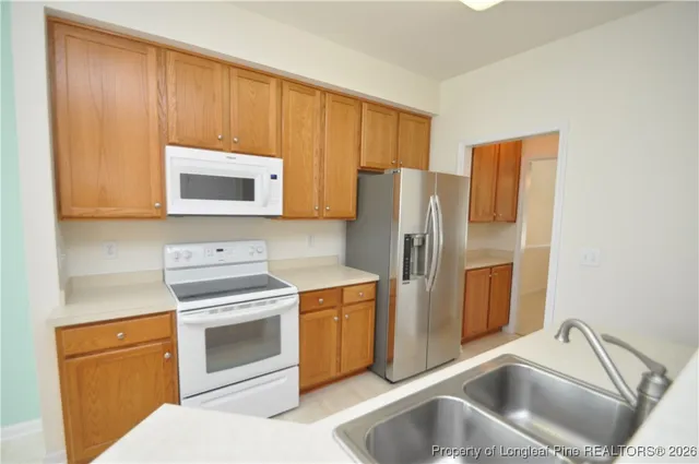 a view of a kitchen with wooden floor and a ceiling fan