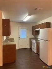 a kitchen with stove cabinets and refrigerator