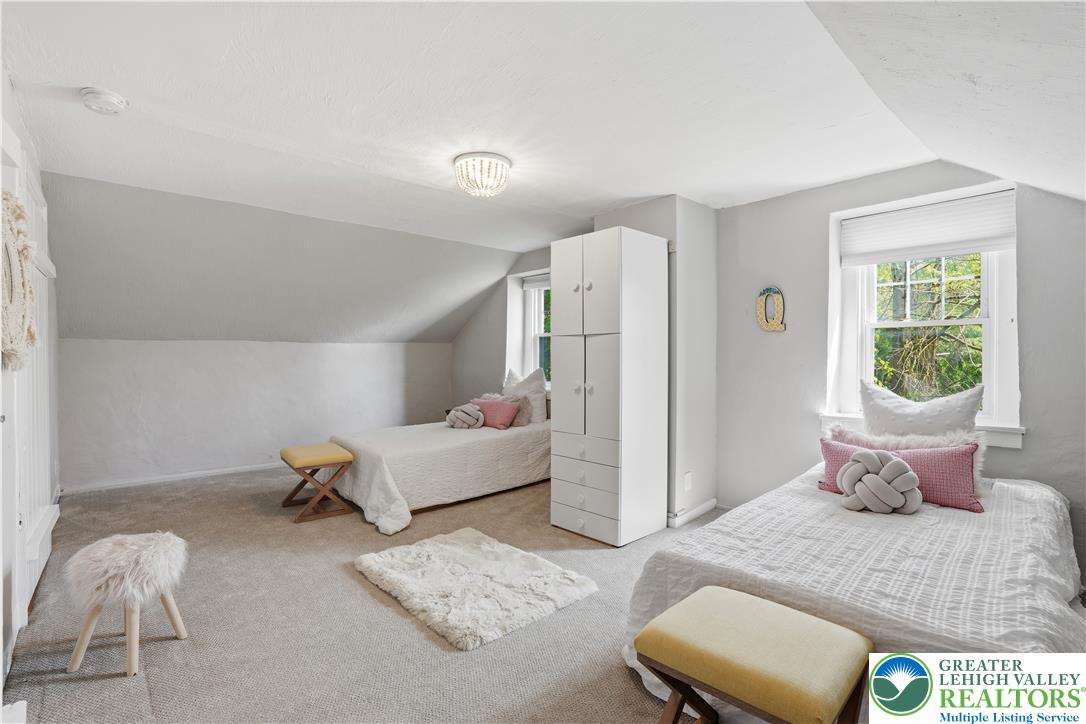 2014 Linden Street Bethlehem, PA 18017 - Photo 18 of 85 A well-lit bedroom features sloped ceilings and cozy twin beds, offering a serene personal retreat.
