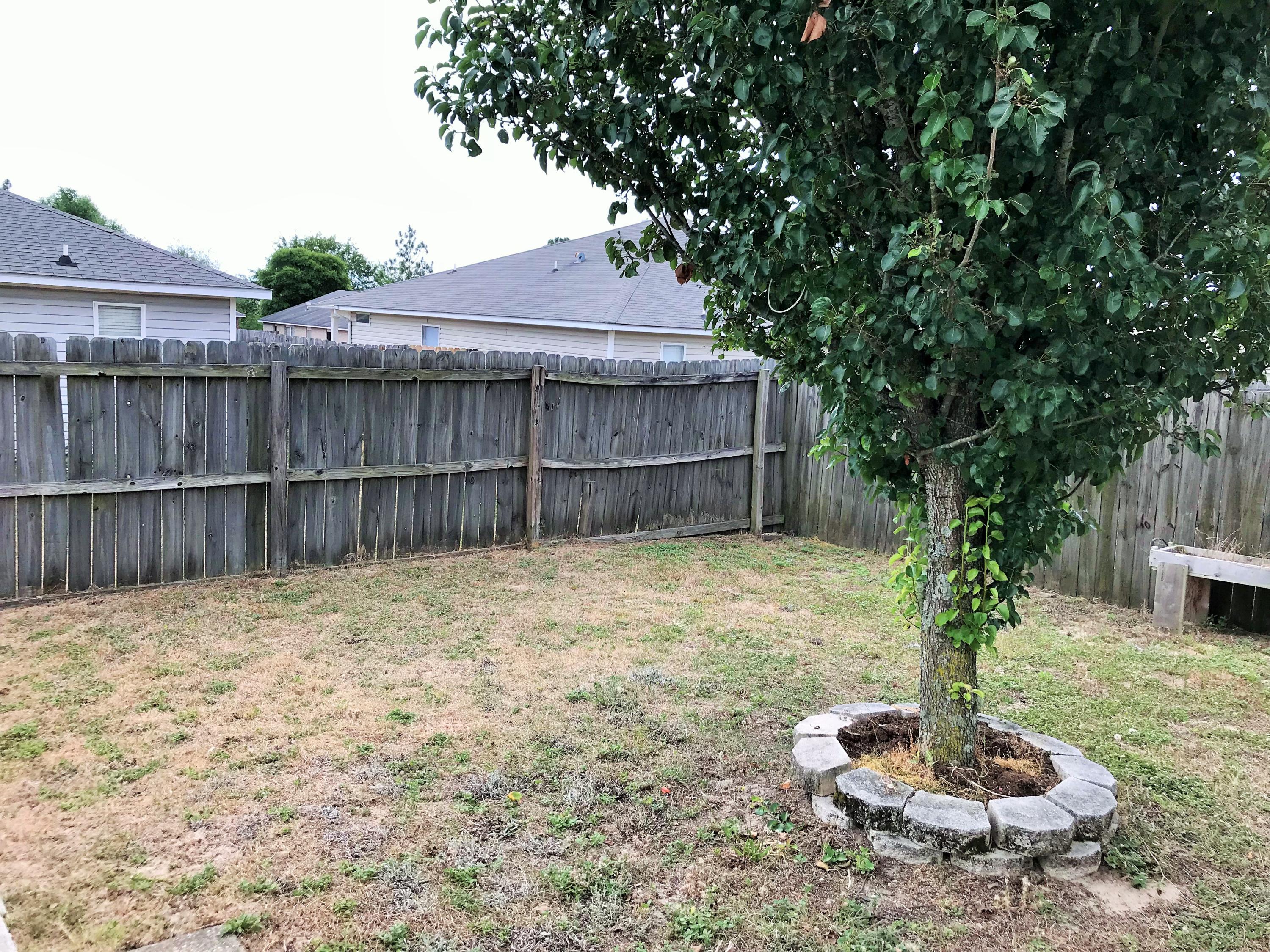 293 Limestone Circle Crestview, FL 32539 - Photo 19 of 20 a backyard of a house with table and a fire pit