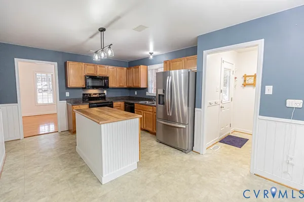 a kitchen with kitchen island a refrigerator stove and microwave