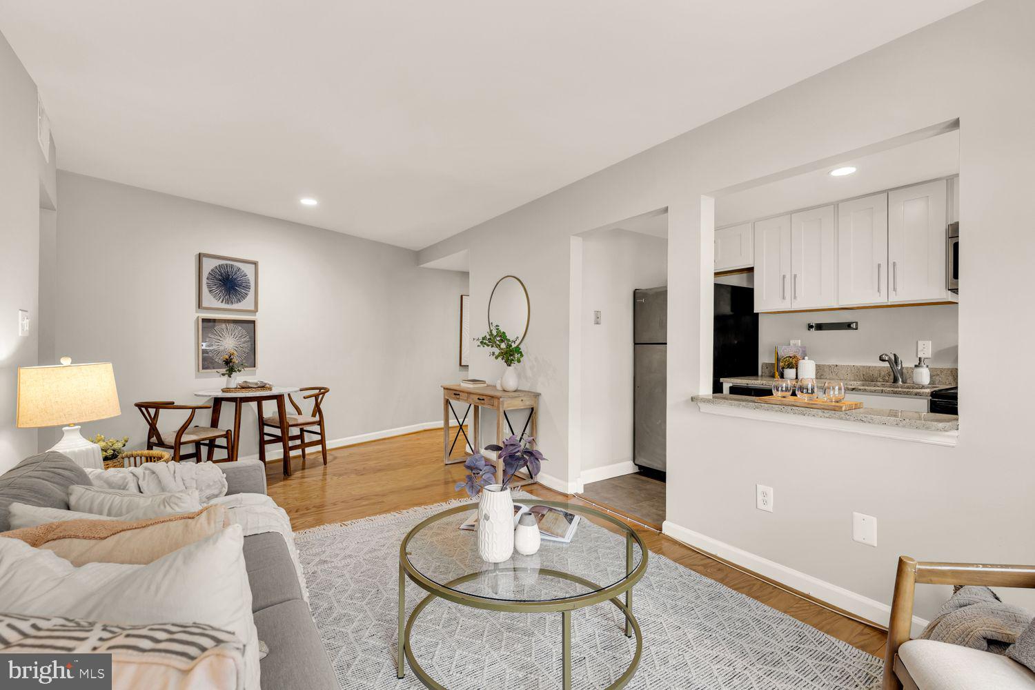 a kitchen with stainless steel appliances granite countertop sink stove refrigerator dining table and chairs