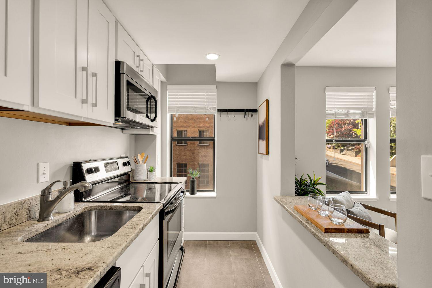 1750 Harvard Street Northwest, Unit 3C Washington, DC 20009 - Photo 12 of 29 a kitchen with stainless steel appliances granite countertop a sink stove and refrigerator