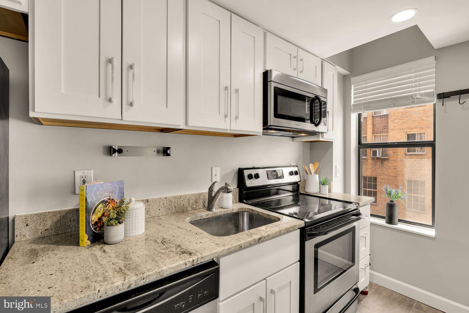 1750 Harvard Street Northwest, Unit 3C Washington, DC 20009 - Photo 13 of 29 a kitchen with stainless steel appliances granite countertop a sink stove and microwave