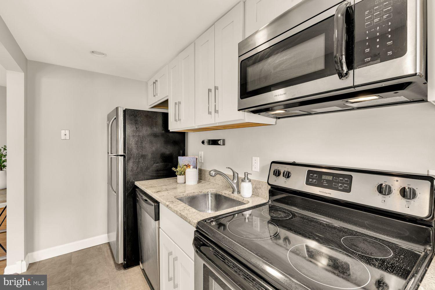1750 Harvard Street Northwest, Unit 3C Washington, DC 20009 - Photo 14 of 29 a kitchen with a stove microwave and refrigerator